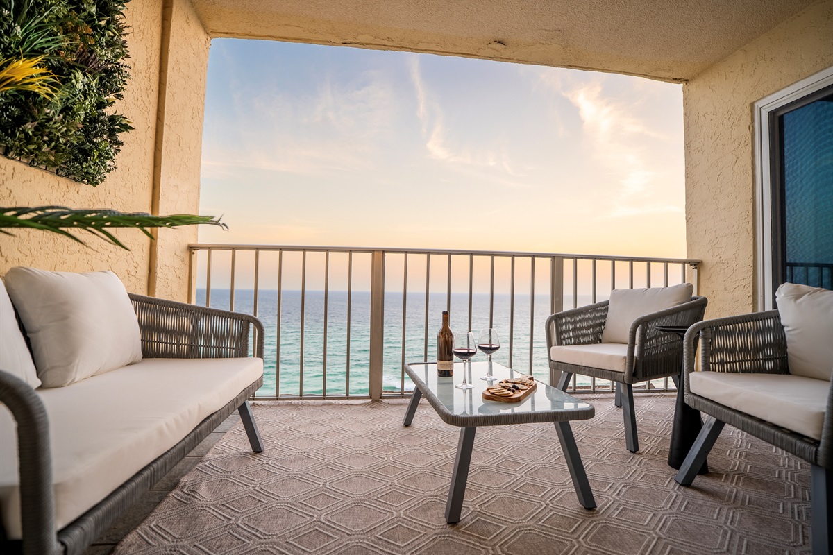 A Gulf-front balcony at sunset in Panama City Beach, two glasses of wine on the table